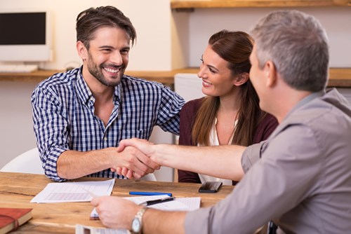 Couple shaking hands with financial agent