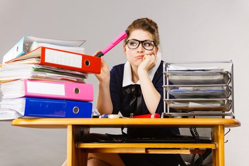 student with mountain of folders