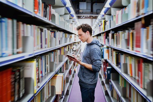 man reading book in library